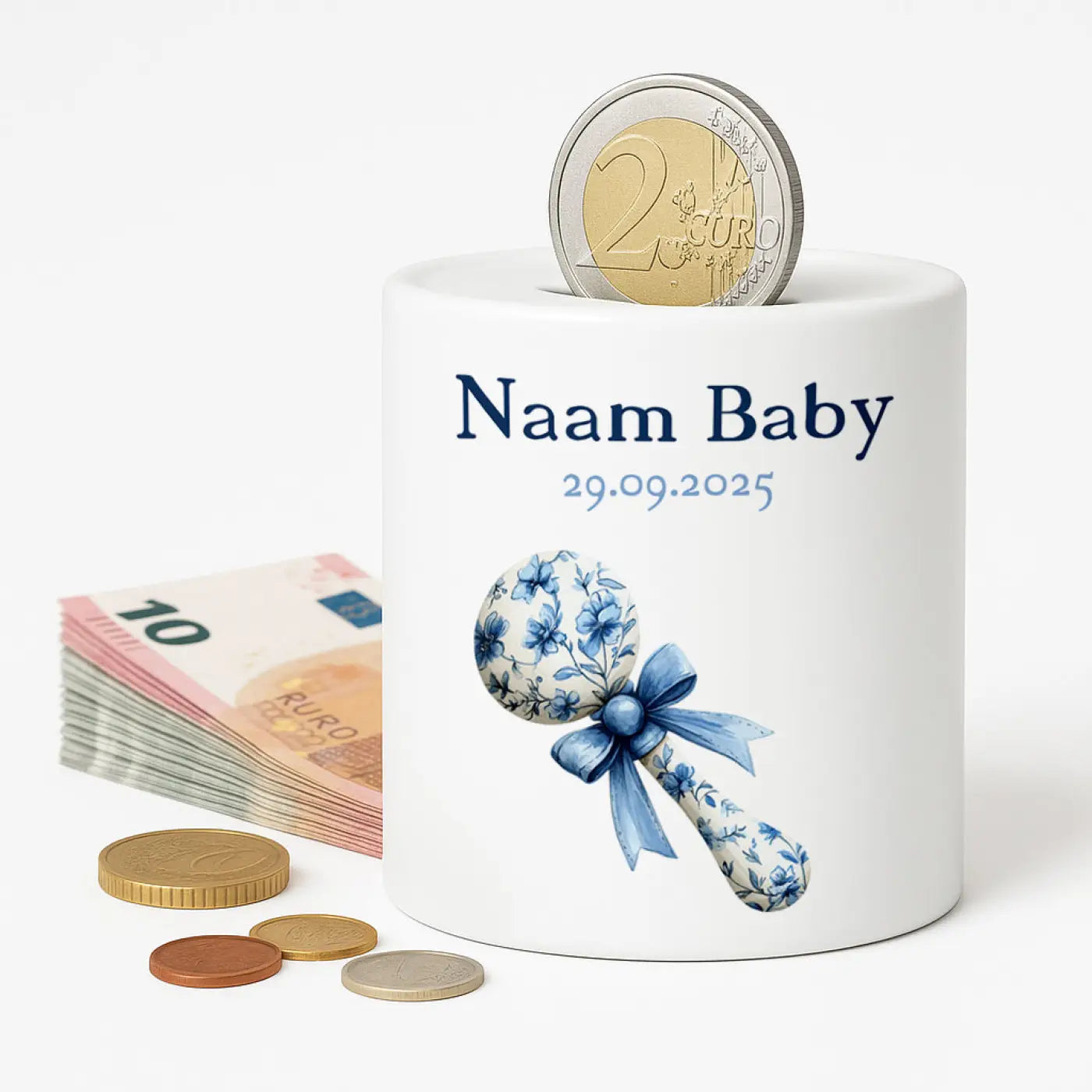 Witte keramische baby spaarpot met blauwe rammelaar bloemmotief naam baby 29.09.2025 en euro munt in opening