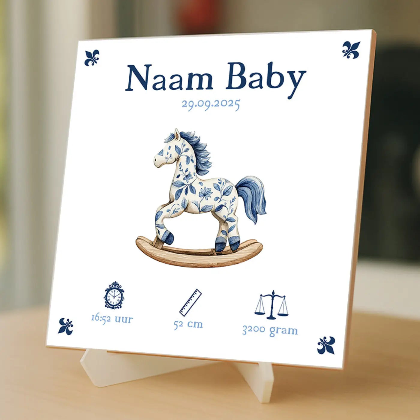 Witte keramische baby tegeltje met blauw wit geïllustreerd hobbelpaard en bloemmotieven