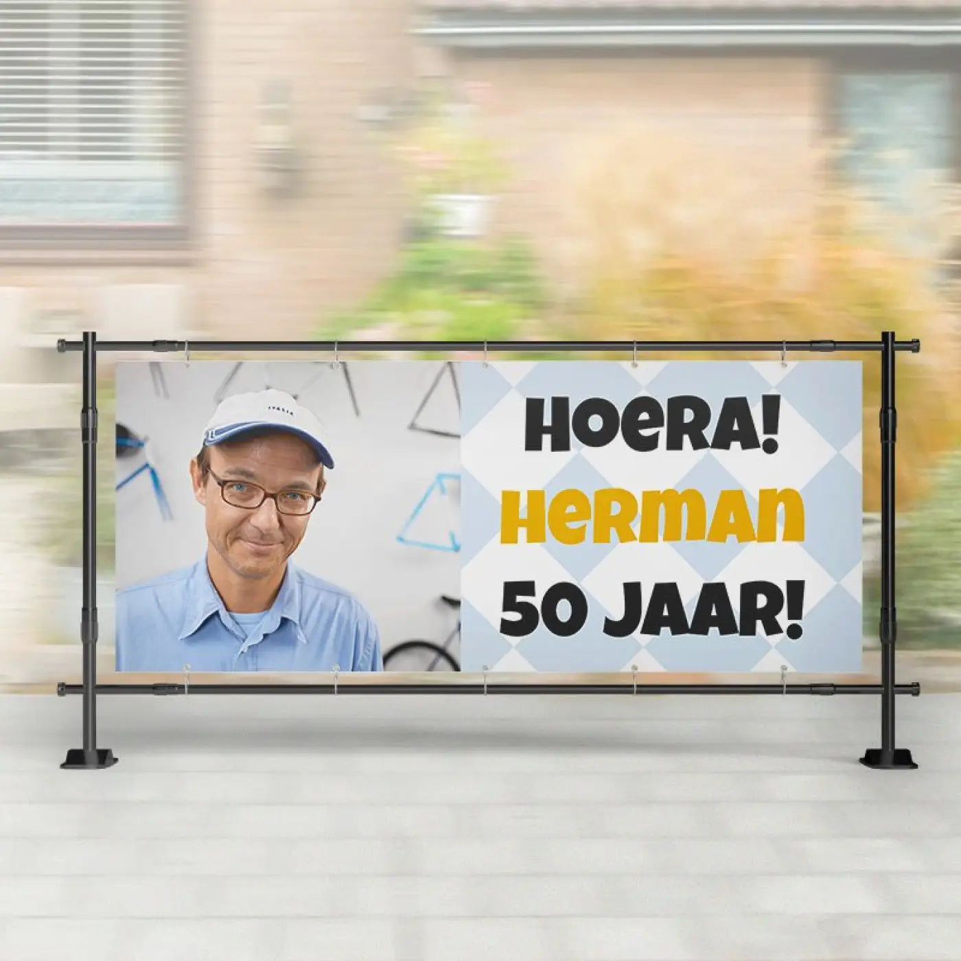 Spandoek abraham verjaardag met foto van man in witte pet en bril en tekst hoera herman 50 jaar op lichtblauwe achtergrond
